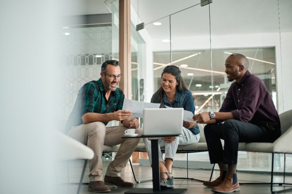 Casual meeting of smiling diverse business team analyzing financial data