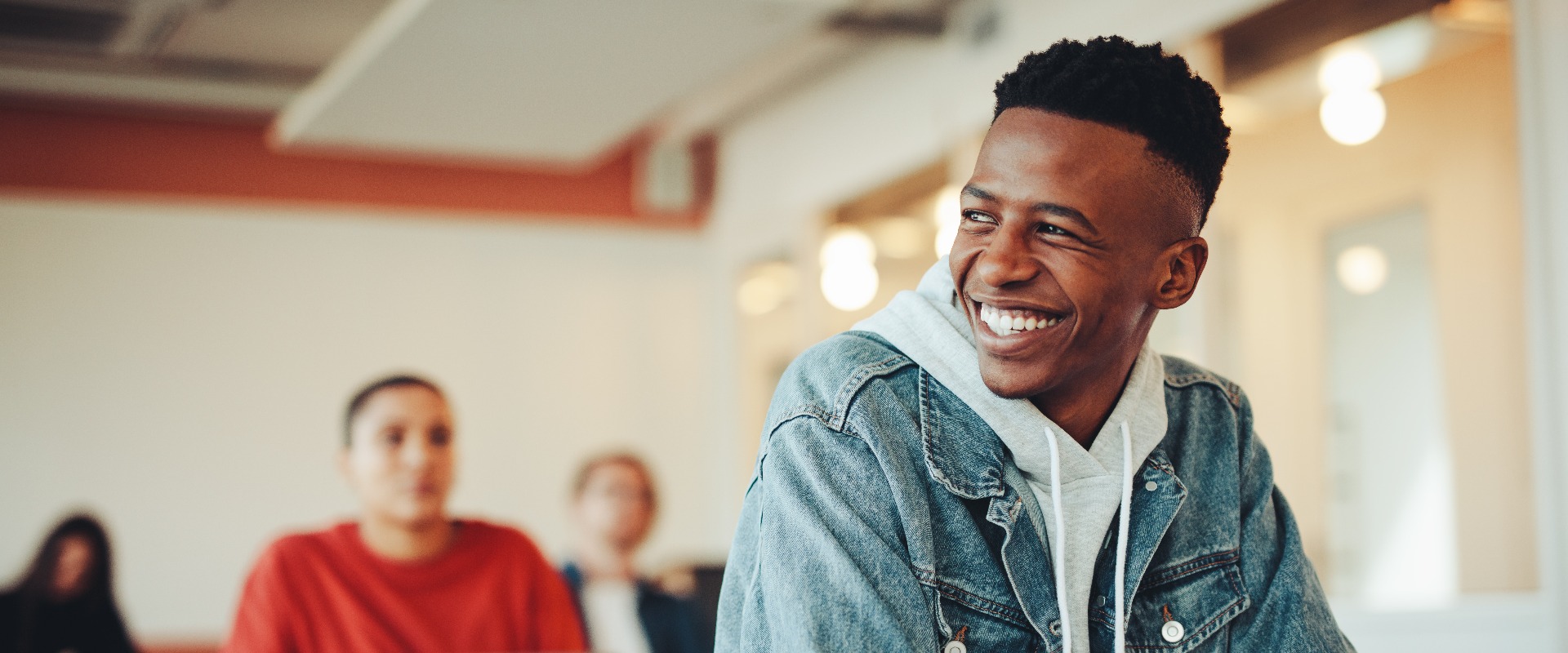 Smiling male student sitting in university classroom